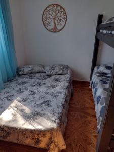 a bedroom with a bed and a tree picture on the wall at Achô na Roça STL in São Thomé das Letras +2 photos