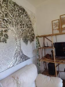 a tree mural on the wall of a living room at Achô na Roça STL in São Thomé das Letras