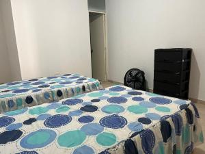 - une chambre avec un lit doté d'une couverture en point de polka dans l'établissement Casa de Playa - Punta Sal, à La Bocana