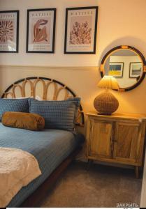 a bedroom with a bed and a table with a mirror at Charming, brand new townhouse near the sea in Hythe