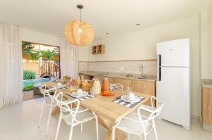 a kitchen and dining room with a table and a refrigerator at Pousada Chaves do Paraíso in São Miguel do Gostoso
