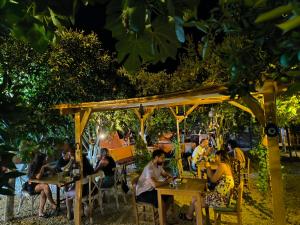 people sitting at tables in a restaurant at night at Litost Cafe in Adrasan