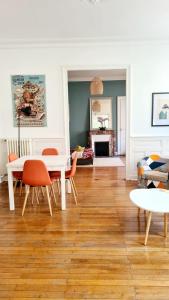 una sala de estar con una mesa y sillas en L'Haussmannien - Hyper centre - Bords de l'Erdre, en Nantes