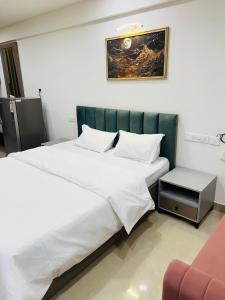 a bedroom with a large white bed and a chair at The Sleepy Monkey in Jaipur
