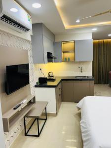 a kitchen and a bedroom with a bed and a television at The Sleepy Monkey in Jaipur