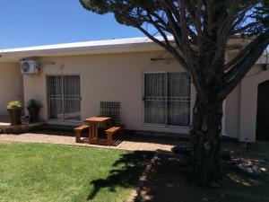 a house with a table and a tree in the yard at Novalia in Colesberg