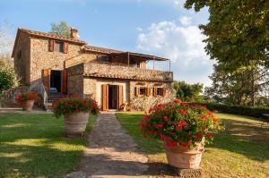 an old stone house with flowers in front of it at Villa Beatrice - Private Heated Pool & Amazing Umbrian Landscape in Corgna