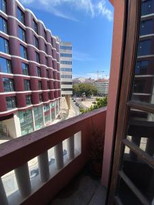 a balcony with a view of a tall building at Garça Real Flats in Porto