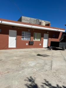 a red brick building with white doors and windows at Maximina Home in Comodoro Rivadavia
