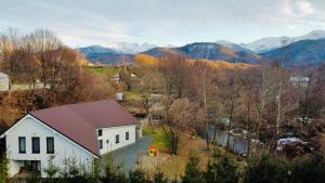 eine Luftaufnahme eines weißen Hauses mit Bergen im Hintergrund in der Unterkunft Riverside Avrig in Avrig + 28 Fotos