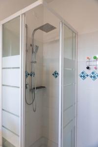 una ducha con puerta de cristal en un baño en Rebby'S Home, en Milán
