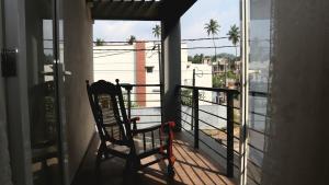 einen Schaukelstuhl auf einem Balkon mit Aussicht in der Unterkunft Fully Furnished 3BR Tourist House in Golf Resort Apartments in Gonapola