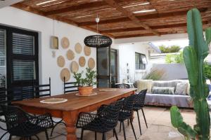 a patio with a wooden table and chairs at sonsandsee in Hermanus