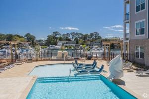 Una gran piscina con sillas y un edificio. en National At Pearl, en Virginia Beach
