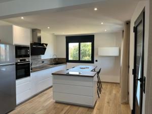 a kitchen with white cabinets and a black counter top at Sole e Mare in Mimizan-Plage