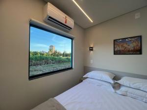 a bedroom with two beds and a large window at Bortolotti Residence in Penha