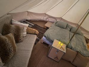 a bedroom with a tent with a couch and a laptop at Foskvallen Lodge in Särna