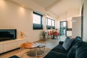 a living room with a couch and a tv and a table at La Casa de Moerkapel in Moerkapelle