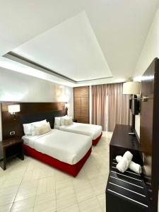 una camera d'albergo con due letti e una scrivania di Hotel Oscar 1 a Rabat