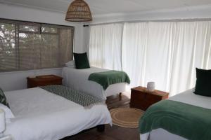 a bedroom with two beds and a window at sonsandsee in Hermanus