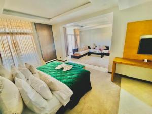 una camera con letto verde e un soggiorno di Hotel Oscar 1 a Rabat