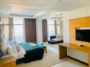 una camera d'albergo con un letto e una TV a schermo piatto di Hotel Oscar 1 a Rabat
