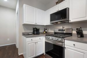 a kitchen with white cabinets and a stove top oven at Seaside Comfort in Gulfport