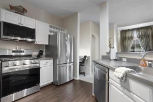 a kitchen with white cabinets and a stainless steel refrigerator at Seaside Comfort in Gulfport