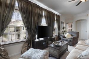 a living room with a television and a couch and a chair at Seaside Comfort in Gulfport