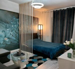图尔恰Blue Studio的一间卧室配有蓝色的床和玻璃桌
