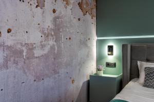 een slaapkamer met een betonnen muur en een bed bij Marcos Studio Nice and Cozy in Piteşti +23 foto's