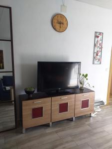 a flat screen tv sitting on top of a wooden cabinet at Casa Juanlu in Málaga