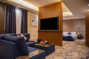 a living room with a couch and a television at شقق حديقة الروابي إين in Jeddah
