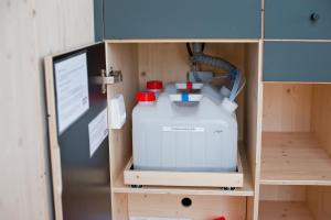 a toy shelf with a cooler and a computer monitor at Green Tiny Village Harz - Sleep Space 36 in Osterode