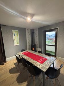 a dining room with a table and chairs and a window at Gite 205 m2, 8pers piscine, jacuzzi, balnéo privatifs in Vagney