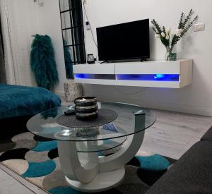 a living room with a glass coffee table and a tv at Blue Studio in Tulcea