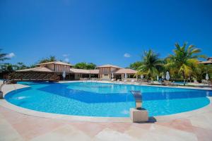 a swimming pool at a resort with palm trees at GB20 Lindo Apto 3/4 - Genipabu Club House in Monte Gordo