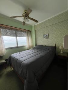 a bedroom with a bed and a ceiling fan at Excelente Depto 2 dormitorios frente y vista al mar playa Varese, Edificio Cabo Corrientes in Mar del Plata