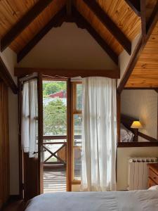 a bedroom with a bed and a large window at Ushuaia Lodge in Ushuaia