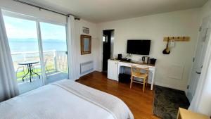 una camera da letto con un letto e una scrivania con una televisione di La Plage Motel a Berthier-sur-Mer