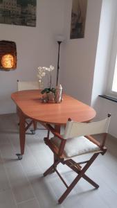 una mesa de madera en una habitación con una silla blanca en Civico 3, en Portofino