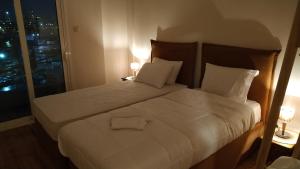 une chambre d'hôtel avec deux lits et une fenêtre dans l'établissement Atelier Poly - Two Bedroom Apartment for 5 Persons -50m to Metro Sintrivani Station- 6th floor plain View - Center -, à Thessalonique