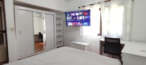a bedroom with a bed and a flat screen tv at Camunda in Punta del Este
