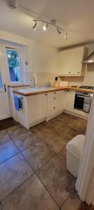 a kitchen with white cabinets and a sink at Bee Cottage in Sandown