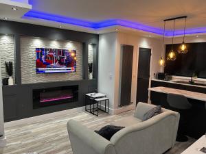 a living room with a couch and a tv on a wall at Modern Junior Suite, Seascale, Cumbria in Seascale