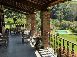 a patio with a table and chairs and a pool at Re-Canto dos Pássaros - Mendes in Mendes +39 photos