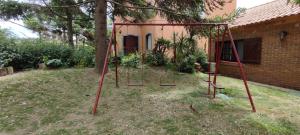 an empty swing set in the yard of a house at Camunda in Punta del Este