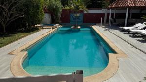 a swimming pool with blue water in a yard at Résidence safari village in Saly Portudal +3 photos