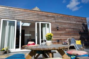 une terrasse avec une table en bois et une maison en bois dans l'établissement 1 Teesdale Road, à Barnard Castle