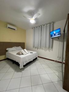 a bedroom with a bed and a flat screen tv at Apto Conquista Imóveis exclusivo para Booking in Vitória da Conquista